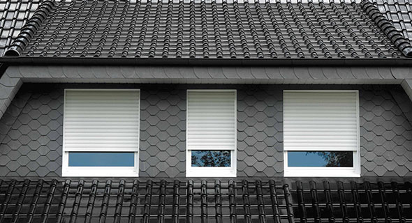 Man schaut durch ein Fenster und sieht eine Frau in einem Sessel mit Kopfhörern